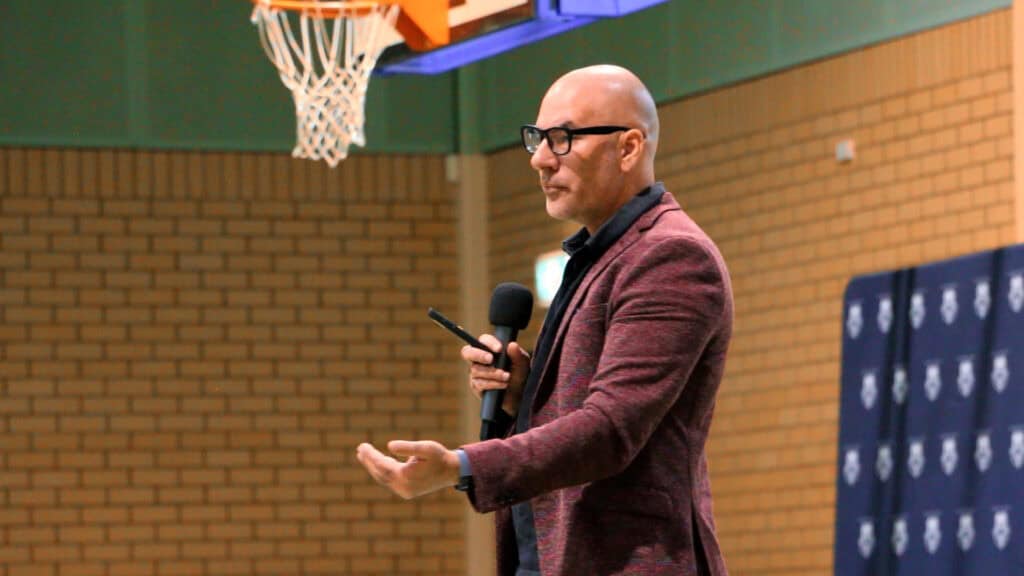 Marshall Ballantine-Jones speaking on a basketball court